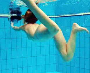 Porno shooting underwater. Naked Young lady unwraps off her